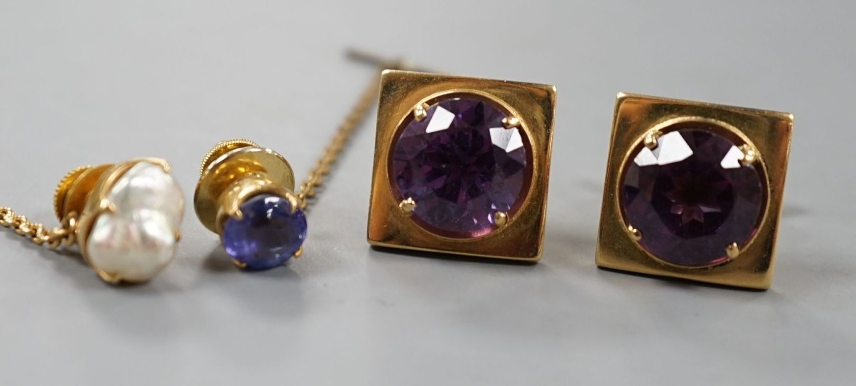 A modern pair of 750 yellow metal and synthetic colour change corundum set cufflinks, a yellow metal and sapphire set pin and similar baroque pearl set pin